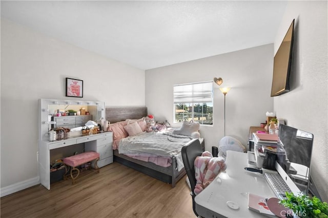 bedroom featuring wood finished floors and baseboards