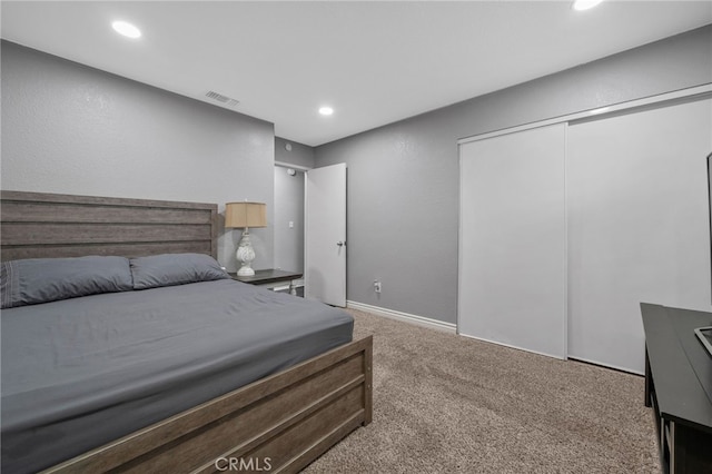 carpeted bedroom featuring recessed lighting, visible vents, and a closet