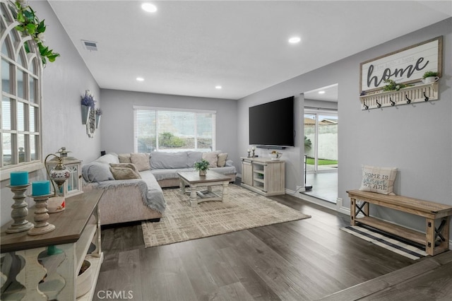 living area with wood finished floors, visible vents, and a wealth of natural light