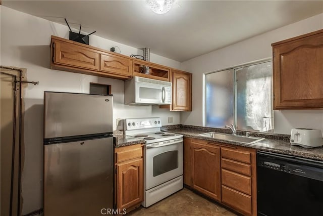 kitchen featuring white appliances, dark countertops, brown cabinets, and a sink