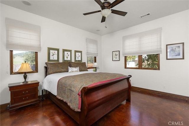 bedroom featuring multiple windows, baseboards, visible vents, and concrete floors