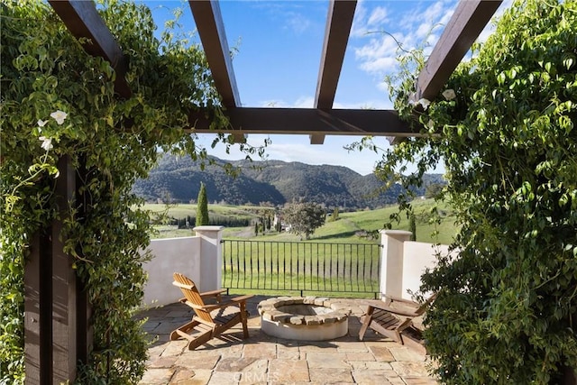 view of patio featuring a mountain view, a rural view, and an outdoor fire pit