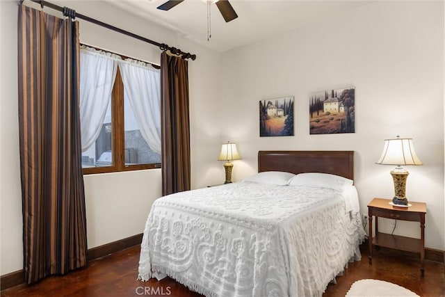 bedroom featuring wood finished floors, baseboards, and ceiling fan