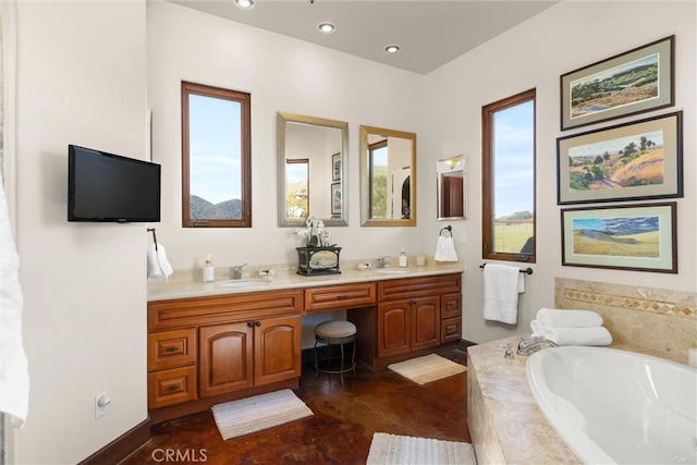 full bath with a garden tub, recessed lighting, double vanity, and a sink