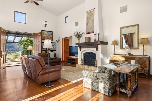 living area featuring visible vents, high vaulted ceiling, a fireplace with raised hearth, and ceiling fan