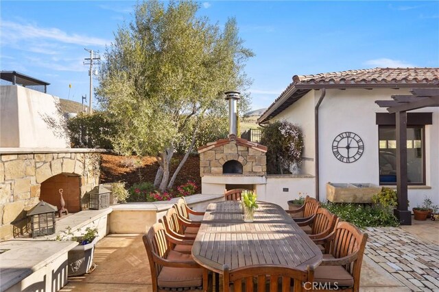 view of patio with outdoor dining space and an outdoor stone fireplace