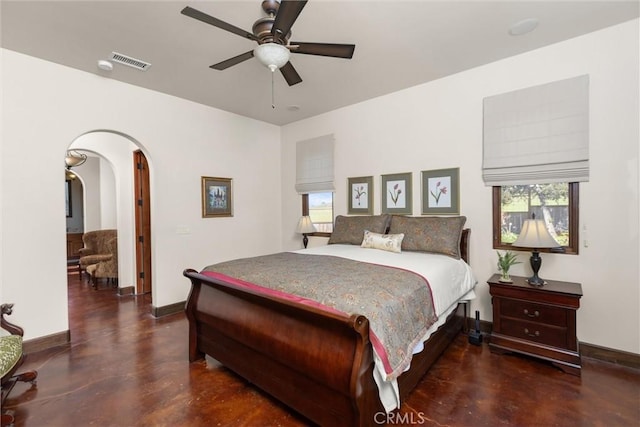 bedroom featuring visible vents, arched walkways, multiple windows, and finished concrete flooring