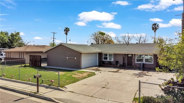 ranch-style home with a fenced front yard, a front yard, stucco siding, a garage, and driveway