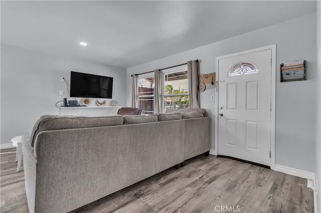 living area with recessed lighting, baseboards, and light wood-style flooring