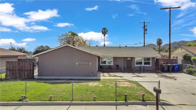 single story home featuring a front lawn, a fenced front yard, and stucco siding