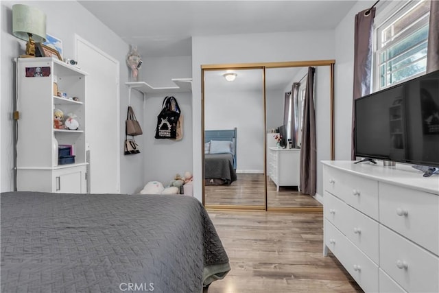 bedroom with light wood-type flooring and a closet