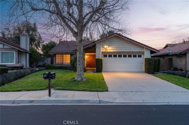 view of front of house featuring driveway, an attached garage, a front lawn, and a tiled roof