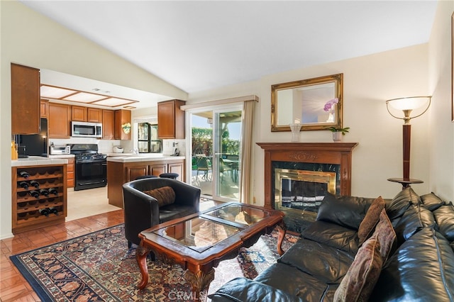 living area with a fireplace and vaulted ceiling