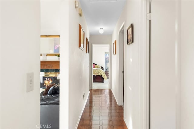 hall with baseboards and dark floors