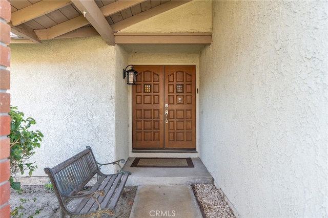 view of exterior entry featuring stucco siding