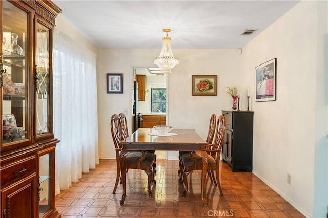 dining room featuring an inviting chandelier, baseboards, and visible vents