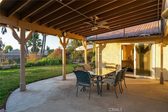 view of patio with outdoor dining space, a ceiling fan, and fence