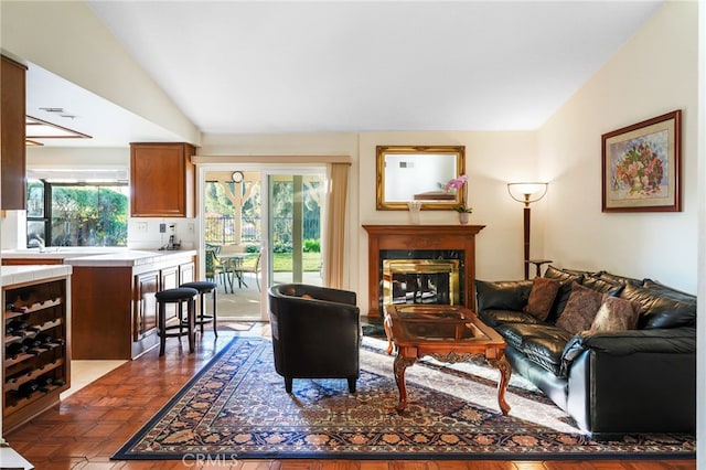 living area featuring wine cooler, a fireplace, and lofted ceiling