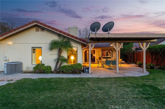 back of property with a patio, central AC unit, fence, a yard, and stucco siding