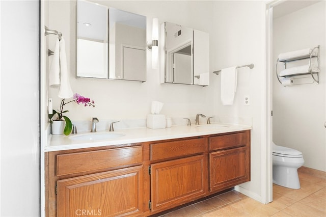 bathroom featuring a sink, toilet, double vanity, and tile patterned floors