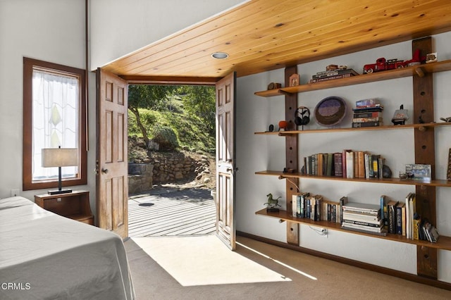 carpeted bedroom with baseboards, wooden ceiling, and access to outside