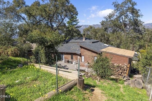 view of home's exterior with a mountain view and a vegetable garden