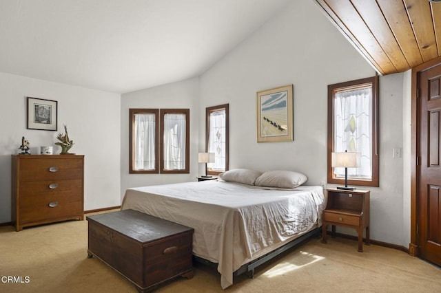 bedroom featuring light colored carpet, baseboards, and vaulted ceiling