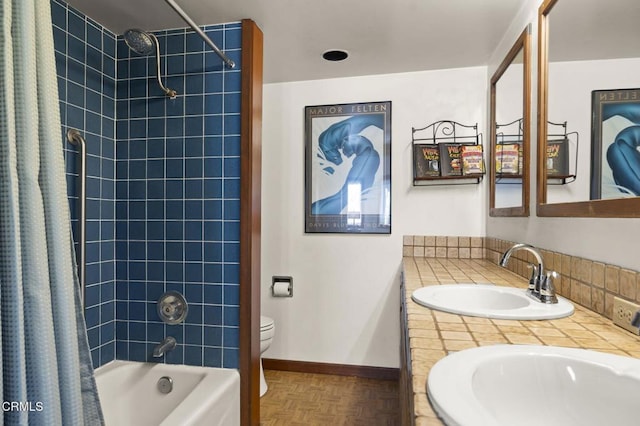 bathroom featuring toilet, a sink, shower / bath combination with curtain, double vanity, and baseboards