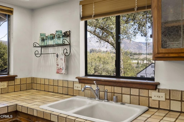 kitchen with a sink, a mountain view, and tile counters