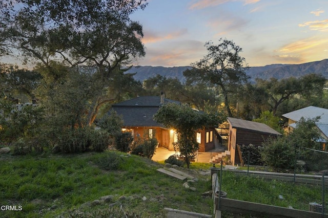 view of front of property with a mountain view and fence