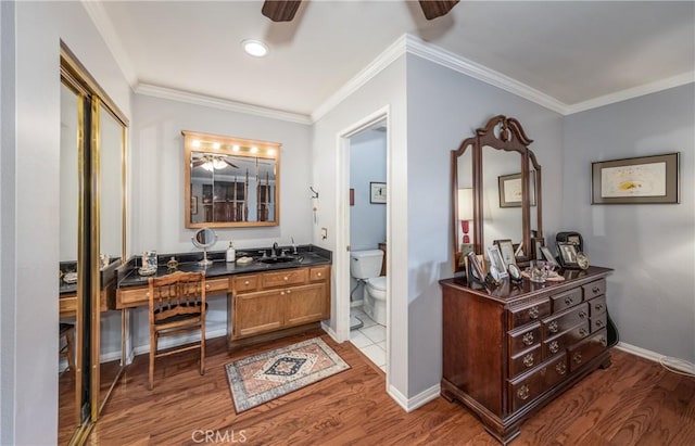 full bath with baseboards, toilet, wood finished floors, and crown molding