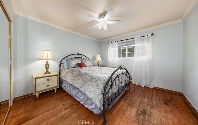 bedroom featuring a closet, crown molding, baseboards, and wood finished floors