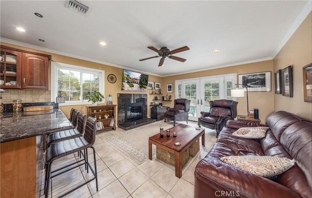 living room with light tile patterned floors, french doors, visible vents, and ornamental molding