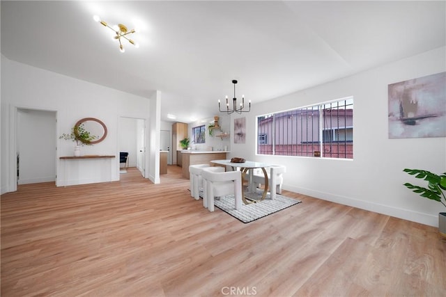 unfurnished dining area with light wood-style flooring, baseboards, and a chandelier