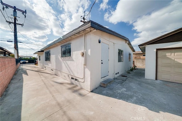 view of home's exterior featuring crawl space and fence