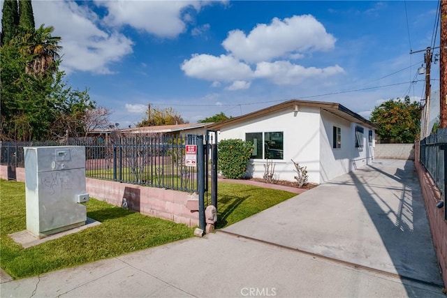 bungalow with stucco siding, fence private yard, and a front yard