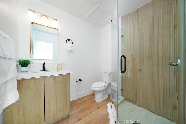 full bathroom featuring a shower stall, baseboards, toilet, wood finished floors, and vanity