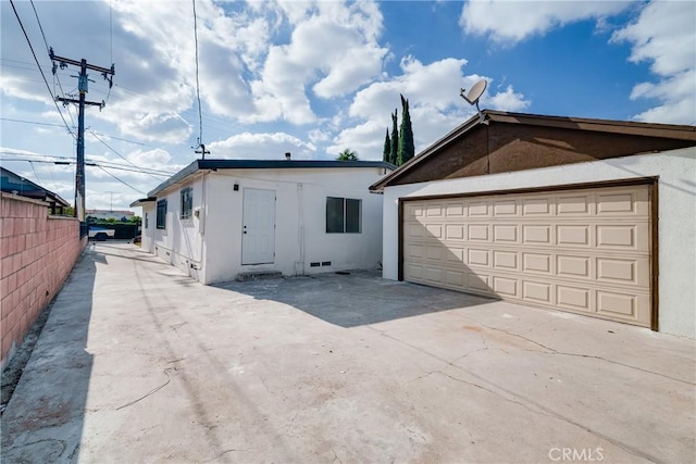 view of front of house featuring an outdoor structure, fence, and stucco siding