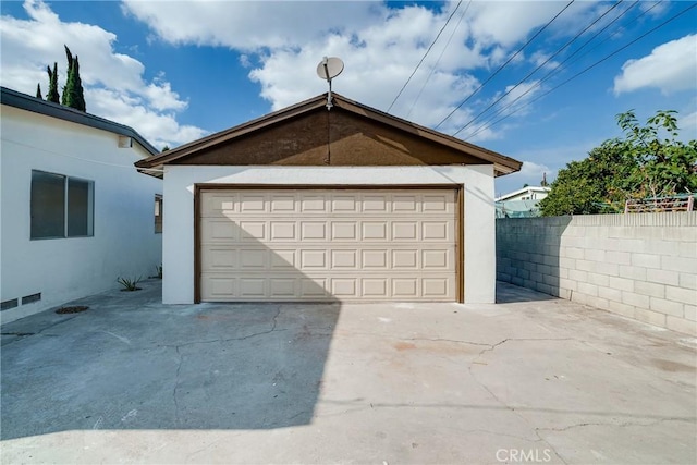 detached garage featuring fence