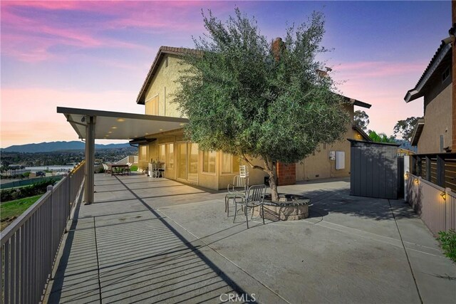 exterior space featuring concrete driveway, an outbuilding, fence, and a shed