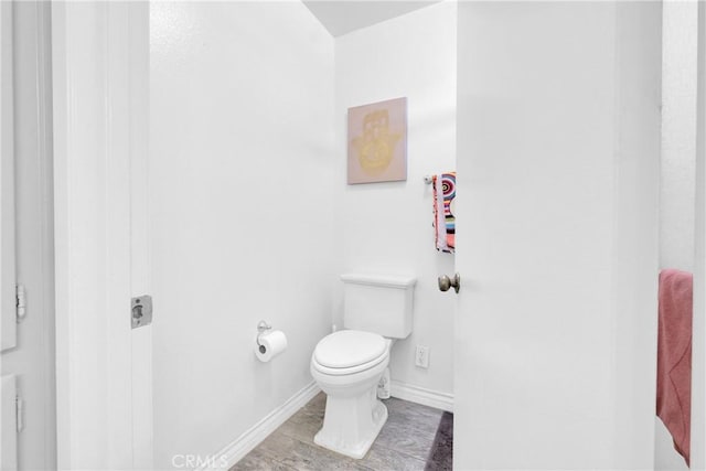 bathroom featuring baseboards and toilet