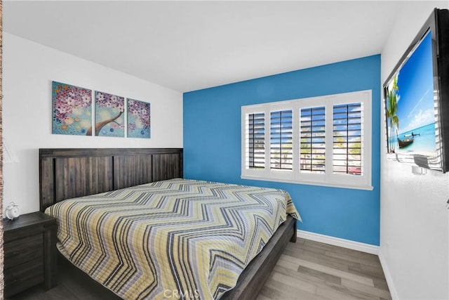 bedroom featuring baseboards and wood finished floors