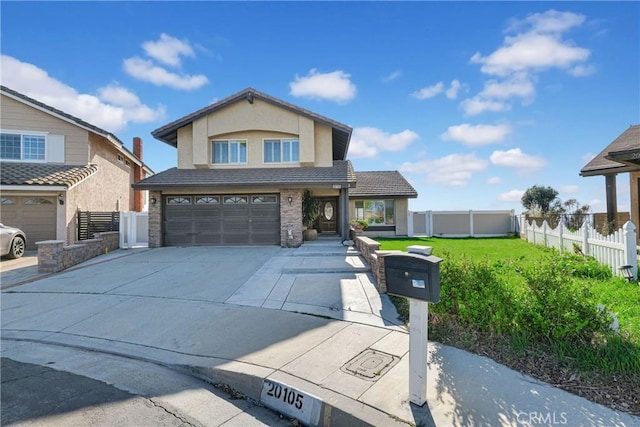 traditional home with fence, concrete driveway, stucco siding, stone siding, and an attached garage