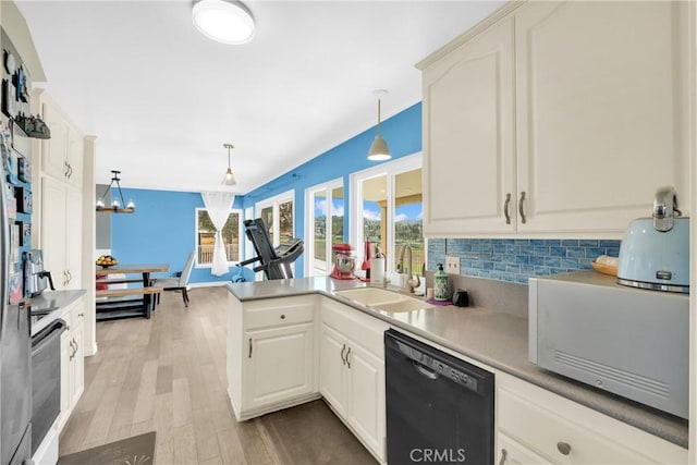 kitchen featuring backsplash, dishwasher, light wood-type flooring, a peninsula, and a sink