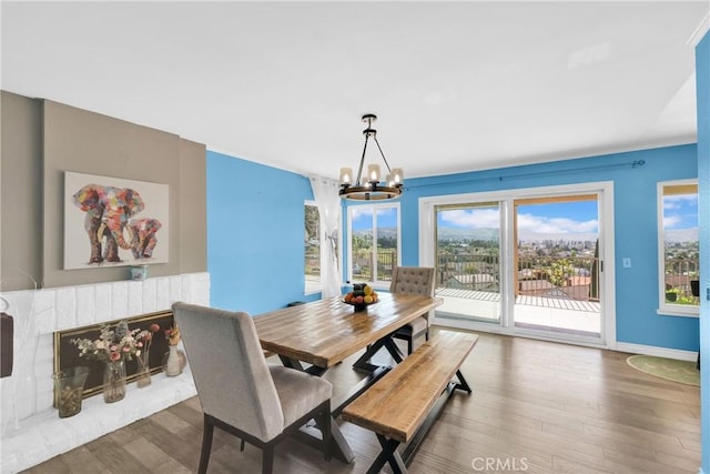 dining room with baseboards, an inviting chandelier, and wood finished floors