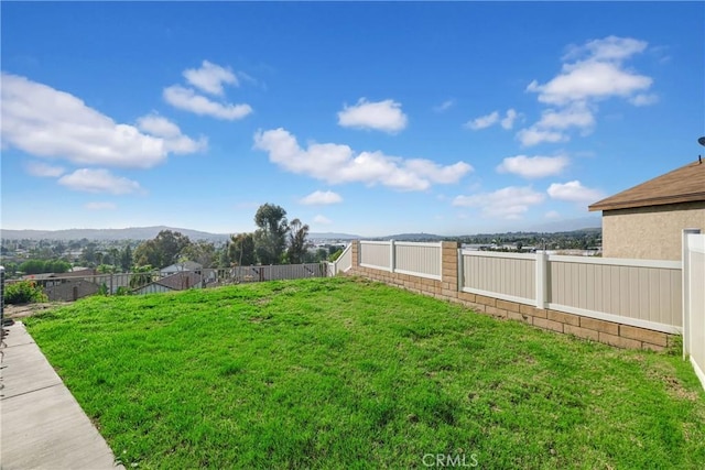 view of yard with a fenced backyard and a mountain view