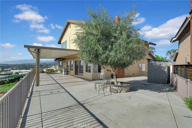 view of patio / terrace with a storage shed, an outdoor structure, and fence