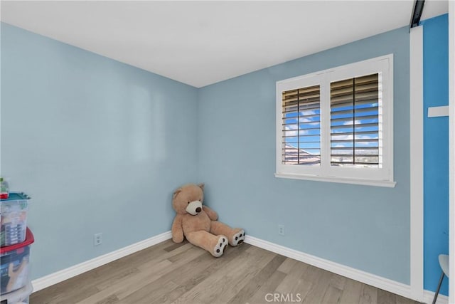 interior space with wood finished floors and baseboards