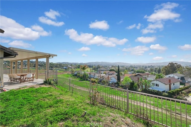 view of yard featuring a mountain view, fence, and a residential view