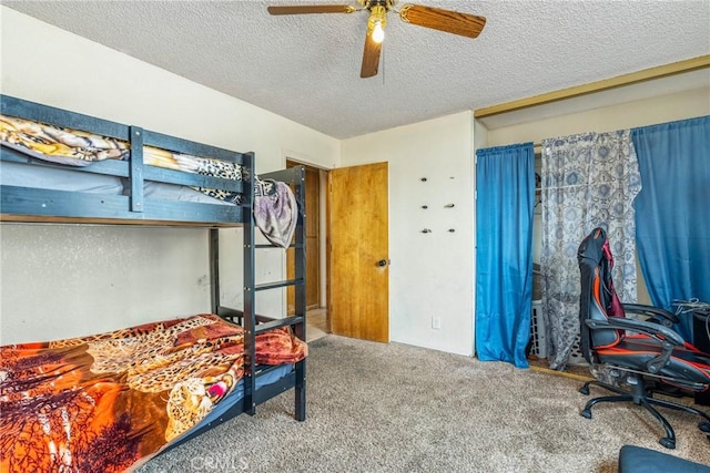 carpeted bedroom featuring a textured ceiling and ceiling fan